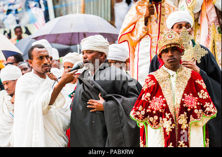 LALIBELA, Äthiopien - Sep 27, 2011: Unbekannter Menschen in Äthiopien mit hellen Kleidung und Sonnenschirme während des Meskel festival Performance in Ehtiopi Stockfoto