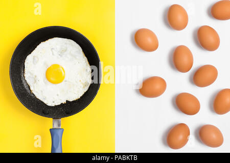 Frisch gekochtes Ei in einer Pfanne mit Ungekochte Eier zufällig über weißen Hintergrund platziert. Flach Bild. Stockfoto