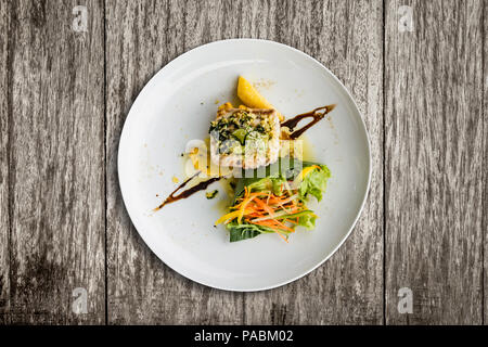 Gegrillter Red Snapper mit Knoblauchbutter Sauce, balinesischen Sauce Salat und knusprige Kartoffelchips. Stockfoto