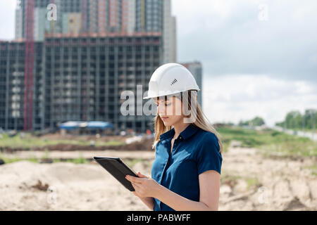 Weibliche Bauingenieur. Architekt mit einem Tablet-PC auf einer Baustelle. Junge Frau suchen, Baustelle auf Hintergrund. Bauweise Stockfoto