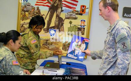 Us-Soldaten Chief Warrant Officer Shereka Catoe, Assistant office Personal Manager und Sgt. 1. Klasse Faipa Wange, die eidgenössische Anerkennung NCOIC, South Carolina Army National Guard, Grüße ein Soldat an der "cross-roads" Symposium an der Allgemeinen Gebäude der Adjutant über bohren Wochenende in Columbia, S.C., 5. März 2016. Die Veranstaltung ist für qualifizierte Soldaten, die im Fenster "reenlistment sind und bietet Briefings über die Vorteile, in der National Guard entwickelt. (U.S. Army National Guard Foto von Oberstleutnant Cindi König/Freigegeben) Stockfoto