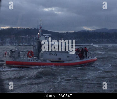 Eine Rettung boatcrew von der Coast Guard Station Bellingham, Washington, rettet drei Männer nach dem 57-Fuß-Schiff Bergen auf die Felsen in der Nähe von Squalicum Harbor, Washington, 10. März 2016 gewaschen. Die drei Männer waren sicher zu Station Bellingham transportiert, und man wurde zu PeaceHealth St. Joseph Medical Center nach der Materialverknappung Hypothermie und angeblich Leiden einer Fußverletzung. U.S. Coast Guard Foto von Petty Officer 3. Klasse Fernando Pratesi. Stockfoto