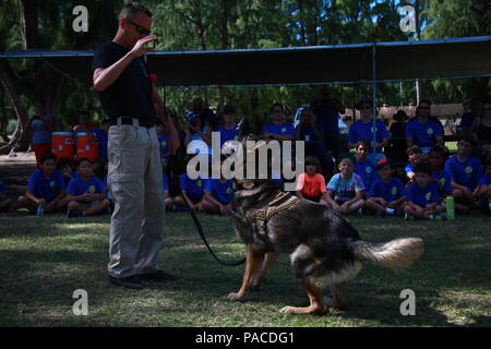 Polizist Kristopher Evers, einen militärischen Gebrauchshund-Handler für die Provost Marshal militärische Arbeitshunde Büroeinheit mit Hauptsitz Bataillon vom Marine Corps Base Hawaii, befiehlt seinen militärischen Gebrauchshund Diego während einer Demonstration für Cub Scout Truppe 311, an Bord der Marine Corps Training Bereich Balg, 5. März 2016. Marines und zivilen Beamten verschiedene Befehle gegeben ihre Hunde, ihre Intelligenz und ihren Gehorsam zu zeigen. Die Hundeführer zermürbte auch eine Biss-Jacke für ein mock nehmen von den Hunden, die Scouts zu zeigen, die Disziplin und Ausbildung der Hunde zeigen, wenn ein echter th vor Stockfoto