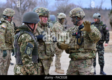 Us-Armee Oberstleutnant Michael Kloepper (rechts), Kommandeur der 2.BATAILLON, 503Rd Infanterie Regiment, 173Rd Airborne Brigade, erklärt Übung Rock Sokol zu Generalleutnant Friedrich 'Ben' Hodges (Mitte), Kommandierender General der US-Armee in Europa und Generalmajor Alan Geder (links), stellvertretender Generalstabschef der slowenischen Streitkräfte, im Rahmen eines Besuches der Brigade an Pocek in Postonja, Slowenien, 16. März 2016. Übung Rock Sokol ist ein bilaterales Training übung zwischen der US-Armee 173rd Airborne Brigade und der slowenischen Streitkräfte, die auf kleinen-unit Taktik und Gebäude auf dem Pre konzentriert Stockfoto