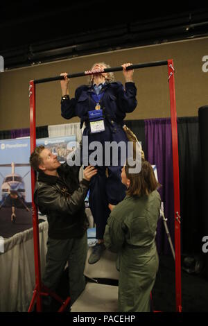 Marine Sergeant Haili Shimko (links), und Marine Kapitän Tina Terry unterstützen Bernice 'Biene' Hadu, Veteran Pilot von Frauen Air Service Pilots (WASP), Durchführung von Pull-ups an der Frauen in der Luftfahrt Internationales Symposium in Nashville, Tenn., den 12. März. Bee ist 95 Jahre alt und war ein Pilot während des Zweiten Weltkriegs mit Wasp, die ersten Frauen amerikanische Flugzeuge zu fliegen. Sie wurde in das Aviation Hall of Fame im Jahr 2000 eingesetzt und die Frauen 2016 in der Luftfahrt International Pioneer Hall of Fame im Jahr 2012. Biene schrieb auch "Briefe 1944-1945", ein Buch über ihre WASP Erfahrung auf die Buchstaben, ihre Mutter von ihr gerettet hatte. Sh Stockfoto