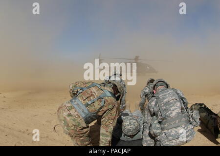 In Fort Bragg, North Carolina, warten Soldaten des 50. Expeditionary Signal Battalion, 35. Signal Brigade, als ein UH-60 Black Hawk vom 3. General Support Aviation Battalion, 82. Combat Aviation Brigade, landet, um ein Opfer zu laden. Die Übung gibt den Soldaten einen Einblick in medizinische Evakuierungsoperationen und ermöglicht es dem gesamten amerikanischen DUSTOFF-Personal, flugmedizinische Fähigkeiten, den Umgang mit Patienten und die Koordination zwischen Luft- und Bodenelementen während medizinischer Notfallmaßnahmen zu üben. Stockfoto