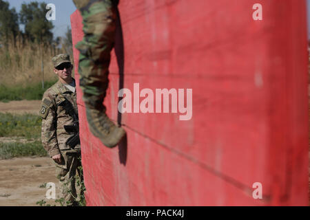 Ein Soldat der US-Armee mit 1St Battalion, 32nd Infantry Regiment, 1st Brigade Combat Team, 10 Mountain Division, wertet ein irakischer Soldat in der Irakischen Ranger Kurs eingeschrieben, als er einen Hindernisparcours im Camp Taji, Irak, 7. März 2016 verhandelt. Die Irakische Ranger Kurs ist eine erweiterte Infanterie Bekämpfung der Schule eingerichtet wurde, um Spezielle Betriebe Soldaten der irakischen Armee auszubilden. Durch die irakischen Sicherheitskräfte durch beraten und unterstützen, und der Aufbau der Kapazitäten Missionen, die Combined Joint Task Force - Betrieb die Lösung der multinationale Koalition unterstützt die Regierung von Stockfoto