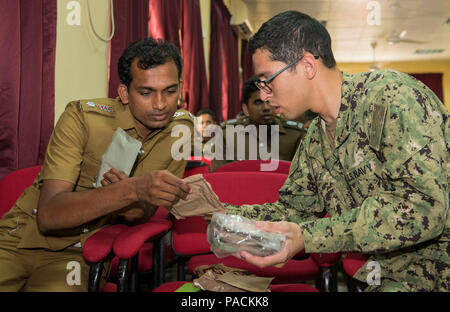 HAMBANTOTA, Sri Lanka (Mar. 11, 2017) Hospital Corpsman Phillip Gomez zeigt eine Mahlzeit, Ready-to-zu Sampath Kumara W. R., Sri Lanka Public Health Inspector Essen, im Hambantota Regional Director of Health Services Office während der Pacific Partnership 2017 Sri Lanka März 11. Pacific Partnership ist die größte jährliche multilaterale humanitäre Hilfe und Katastrophenhilfe Abwehrbereitschaft mission in der Indo-Asia durchgeführt - Pazifik und zielt darauf ab, regionale Koordination in Bereichen wie medizinische Bereitschaft und Vorsorge für synthetische und natürliche Katastrophen zu verbessern. Stockfoto