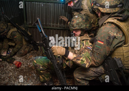 German Medical Soldaten vorher Combat casualty Care als Antwort auf eine simulierte Sprengkörper während Tactical Combat Casualty Care Kurs improvisiert, dass multinationale Soldaten aus NATO-Ländern die Teilnahme an der internationalen Special Training Center Train the Trainer Kurs, in dem die Hälfte der Teilnehmer Tactical combat Casualty care Lernen und die andere Hälfte Lernen, die Bekämpfung der Unfall- Kurs zu unterrichten. Das Training wurde von General Staufer Kaserne, 16. März 2016 durchgeführt. (U.S. Armee Foto von visuellen Informationen Spezialist Martin Greeson/Freigegeben) Stockfoto