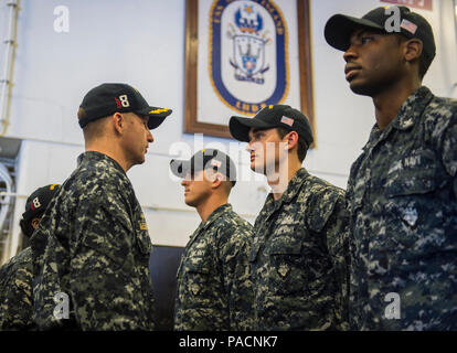 Pazifik (21. April 2017) USS Makin Island befehlshabenden Offizier, Kapitän Mark A. Melson, Links, spricht mit Feuer Controlman 2. Klasse Briley Dixon, von Sioux City, Iowa, während eine Teilanmeldung einheitliche Inspektion im Hangar Bucht des Amphibious Assault Ship. Makin Island, das Flaggschiff der Makin Island amphibischen bereit, mit der begonnen 11 Marine Expeditionary Unit, arbeitet in der Indo-Asia-pazifischen Region amphibische Fähigkeit mit regionalen Partnern zu verbessern und als gebrauchsfertige Response Force für jede Art der Kontingenz zu dienen. Stockfoto