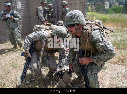 FORT HUNTER LIGGETT, Calif. (14. Mai 2017) Seabees zu Naval Mobile Konstruktion Bataillon (NMCB) 4 zugewiesenen Aufgaben ein sechs-Mann Wurf tragen während einer Messe Unfallversicherung Bohrer für NMCB 4's Field Training Übung (Ftx). Die Ftx bereitet und Tests, die Fähigkeit des Bataillon feindliche Standorte einzugeben, zugewiesenen Bauvorhaben bauen und verteidigen gegen feindliche Angriffe mit realistischen Szenarien, während Sie von Naval Construction Group 1 ausgewertet wird. Stockfoto