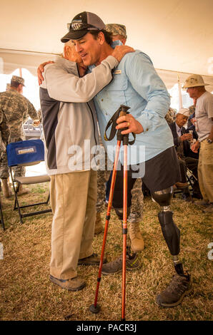 Ehemalige Marine Special Operations Master Chief Harold Bologna, ein doppeltes amputee, umarmt U.S. Army Oberst und Bataan Death March Überlebender Ben Skardon, 98, Rentner, nachdem sie jeweils mehr als 8 Meilen in der 27. jährlichen Bataan Gedenkstätte Todesmarsch im White Sands Missile Range, N.M., 20. März 2016 ging. (U.S. Armee Foto: Staff Sgt. Ken Narbe) Stockfoto