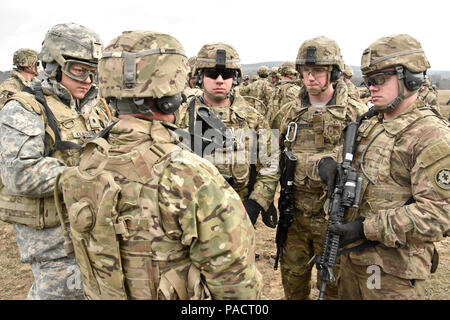 Staff Sgt. Michael Mooney (vorne links), eine Kanone Crew Chief zu Archer Batterie, Field Artillery Squadron, 2.Kavallerie Regiment zugeordnet, unterweist seine Troopers auf Ihre bevorstehenden Mission während M777 Haubitze Schlinge last Betrieb der Einheit mit Soldaten durchgeführt vom 12 Combat Aviation Brigade (Hubschrauber Loslösung) Grafenwöhr Training Area, in der Nähe der Rose Barracks, Deutschland, 23. März 2016. Ziel der Veranstaltung war die Artillerie Tabelle II Training beim Helfen Arbeiten zwischen 2 CR-Field Artillery Squadron und der 12 CAB zu etablieren. (U.S. Armee Foto von Stockfoto