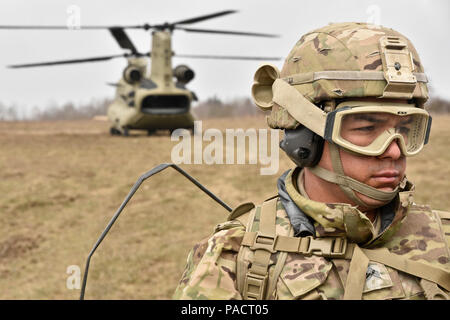 Sgt. Engel Peralta, eine Kanone Crew Mitglied zu Archer Batterie, Field Artillery Squadron, 2.Kavallerie Regiment zugeordnet ist, wird in eine CH-47 Chinook Hubschrauber Board aus dem 12 Combat Aviation Brigade (Hubschrauber Loslösung) während der M777 Haubitze schlinge Ladevorgänge seiner Einheit an der Grafenwöhr Training Area durchgeführt, in der Nähe der Rose Barracks, Deutschland, 23. März 2016 zu. Ziel der Veranstaltung war die Artillerie Tabelle II Training beim Helfen Arbeiten zwischen 2 CR-Field Artillery Squadron und der 12 CAB zu etablieren. (U.S. Armee Foto von Sgt. William A. Tanner) Stockfoto