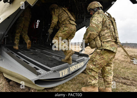 Staff Sgt. Michael Mooney (rechts), eine Kanone Crew Chief zu Archer Batterie, Field Artillery Squadron, 2.Kavallerie Regiment zugeordnet, folgt seinem Squad, da sie eine CH-47 Chinook Hubschrauber Board aus dem 12 Combat Aviation Brigade (Hubschrauber Loslösung) während der M777 Haubitze Schlinge laden die Tätigkeit ihrer Einheit an der Grafenwöhr Training Area durchgeführt, in der Nähe der Rose Barracks, Deutschland, 23. März 2016. Ziel der Veranstaltung war die Artillerie Tabelle II Training beim Helfen Arbeiten zwischen 2 CR-Field Artillery Squadron und der 12 CAB zu etablieren. (U.S. Armee Foto von Sgt Stockfoto