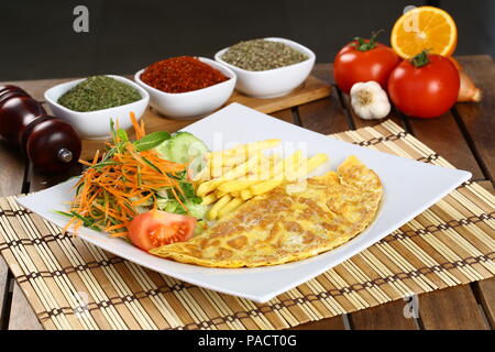 Frühstück Omelette mit Pommes Frites und Garnieren Stockfoto