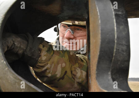 Staff Sgt. Michael Mooney, eine Kanone Crew Chief zu Archer Batterie, Field Artillery Squadron, 2.Kavallerie Regiment zugeordnet, löscht die Schnauze von M 777 seiner Maßeinheit Haubitze nach seiner Mannschaft, zusammen mit ihrer Ausrüstung, wurden von einem Anschlag zum anderen über eine CH-47 Chinook Hubschrauber aus dem 12 Combat Aviation Brigade (Hubschrauber Loslösung) während der Schlinge laden die Tätigkeit ihrer Einheit an der Grafenwöhr Training Area durchgeführt, in der Nähe der Rose Barracks, Deutschland, 23. März 2016 übertragen werden entfernt. Ziel der Veranstaltung war die Artillerie Tabelle II Training beim Helfen workin zu schaffen Stockfoto