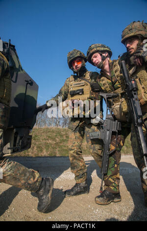 Deutsche Soldaten helfen einem verletzten Soldaten nach einem simulierten Improvised Explosive detonation an einem Fahrzeug während eines Taktisches Unfallversicherung Care Kurs, dass multinationale Soldaten aus NATO-Ländern die Teilnahme an der Internationalen Schulungszentrum, Train the Trainer Kurs enthalten. Die Hälfte der Teilnehmer lernen Tactical combat casualty Care und die andere Hälfte Lernen, die Bekämpfung der Unfall- Kurs zu unterrichten. Das Training wurde von General Staufer Kaserne, Pfullendorf, Deutschland, 16. März 2016 (in den USA durchgeführt. Armee Foto von visuellen Informationen Spezialist Martin Greeson/Freigegeben) Stockfoto