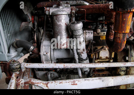 Alten Traktor Motor mit vielen Änderungen. Rostig, aber funktionstüchtig. Alte landwirtschaftliche Maschinen. Stockfoto