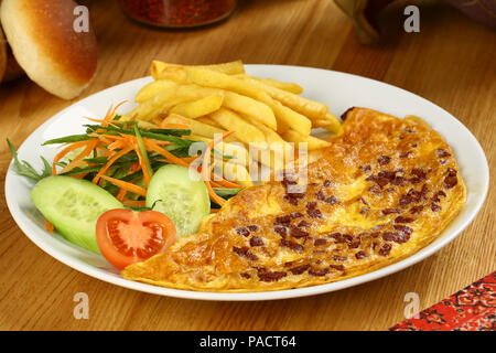 Frühstück Omelette mit Pommes Frites und Garnieren Stockfoto