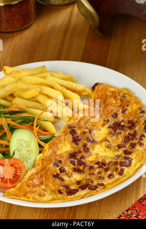 Frühstück Omelette mit Pommes Frites und Garnieren Stockfoto