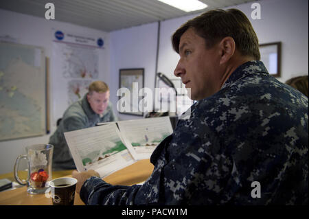 Grönland (Sep. 7, 2017) Lt.Cmdr. John Woods, Büro der Naval Research (ONR) finden Komponente, erhält ein Wetter kurze von Staff Sgt. Daniel Davis von der 821St Operative Unterstützung Wetter Squadron bei Thule Air Force Base in Grönland, vor einer Boje Bereitstellung Mission über der Hohen Arktis in der Nähe des Nordpols. Die Luft Verschleißteil Eis Beacons (AXIB) Bojen wurden von einem Königlichen Dänischen Luftwaffe C-130 Flugzeugen eingesetzt als Teil der International Arctic Boje Programm (IABP). Die IABP ist eine Ansammlung von internationaler Teilnehmer, die ein Netzwerk von driften Bojen im Arktischen Ozean, provi Stockfoto