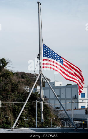 160323-N-OI 810-057 Yokosuka, Japan (23. März 2016) Die Fahne fliegt auf Halbmast an Bord der US-Navy ist nur Vorwärts - bereitgestellt Flugzeugträger USS Ronald Reagan (CVN 76) in Erinnerung an die während der Brüsseler verloren, Belgien Terroranschläge, März 22. Dutzende Menschen starben und Hunderte mehr aus der Bombenanschläge in Zaventem Flughafen und einen Bahnhof in der Nähe des Bahnhof Maelbeek verwundet. (U.S. Marine Foto von Mass Communication Specialist 3. Klasse Nathan Burke/Freigegeben) Stockfoto