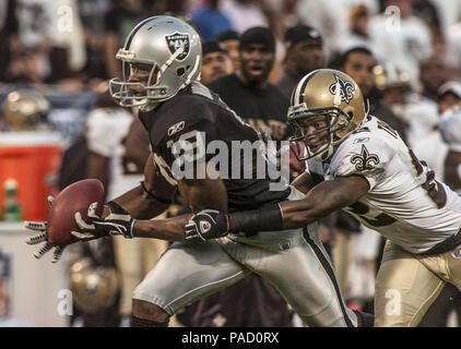 Oakland, Kalifornien, USA. 1. Sep 2005. Oakland Raiders wide receiver Johnnie Morant (19) fängt den Ball mit New Orleans Saints Defensive zurück Fred Thomas (22) hinter dem am Donnerstag, dem 1. September 2005 in Oakland, Kalifornien. Die Räuber besiegt die Heiligen 13-6 in einem preseason Spiel. Credit: Al Golub/ZUMA Draht/Alamy leben Nachrichten Stockfoto