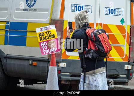 Glasgow, Renfrewshire, Großbritannien. 21. Juli 2018. Ein Tourist gesehen Fotografieren von Poster während des Protestes. Auseinandersetzungen während des Protestes zwischen Mitgliedern der ultra-rechten Gruppe schottischer Defence League (SDL) und Mitglieder der verschiedenen Antifaschismus Gruppen, einschließlich Antifa, Schottland Polizei gerettet Mitglieder aus der Auseinandersetzungen. Credit: Stewart Kirby/SOPA Images/ZUMA Draht/Alamy leben Nachrichten Stockfoto