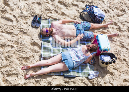 Bournemouth, Dorset, Großbritannien. 22. Juli 2018. UK Wetter: heiß und sonnig in Bournemouth Strände, als Sonnenanbeter Kopf ans Meer, um Sonne zu tanken. Paar Sonnenbaden am Strand - von oben nach unten auf. Credit: Carolyn Jenkins/Alamy leben Nachrichten Stockfoto