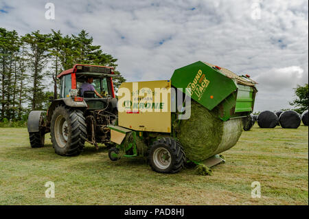 Ballydehob, West Cork, Irland. 22. Juli, 2018. Hollum basierte Landwirt Michael Pat Ward sammelt Gras für die Herstellung von silage Querhölzer auf einem anderen sehr heißen Tag in Irland. Das Wetter ist wechselhaft im Laufe der nächsten Tage mit Regen Prognose für die ganze Woche. Die Temperaturen an den hohen Teens fallen/Low 20 Celsius. Credit: Andy Gibson/Alamy Leben Nachrichten. Stockfoto