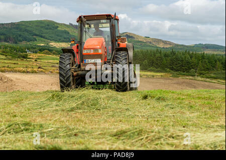 Ballydehob, West Cork, Irland. 22. Juli, 2018. Hollum basierte Landwirt Michael Pat Ward sammelt Gras für die Herstellung von silage Querhölzer auf einem anderen sehr heißen Tag in Irland. Das Wetter ist wechselhaft im Laufe der nächsten Tage mit Regen Prognose für die ganze Woche. Die Temperaturen an den hohen Teens fallen/Low 20 Celsius. Credit: Andy Gibson/Alamy Leben Nachrichten. Stockfoto