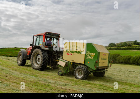 Ballydehob, West Cork, Irland. 22. Juli, 2018. Hollum basierte Landwirt Michael Pat Ward sammelt Gras für die Herstellung von silage Querhölzer auf einem anderen sehr heißen Tag in Irland. Das Wetter ist wechselhaft im Laufe der nächsten Tage mit Regen Prognose für die ganze Woche. Die Temperaturen an den hohen Teens fallen/Low 20 Celsius. Credit: Andy Gibson/Alamy Leben Nachrichten. Stockfoto