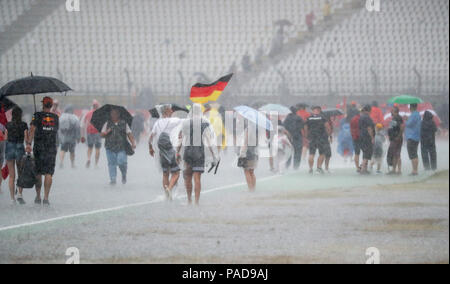 Hockenheim, Deutschland. 22. Juli, 2018. Motorsport: Formel-One-Meisterschaften, Grand Prix von Deutschland. Fans zu Fuß über die Rennstrecke nach der Preisverleihung während eines Sturms. Kredite: Jan Woitas/dpa-Zentralbild/dpa/Alamy leben Nachrichten Stockfoto