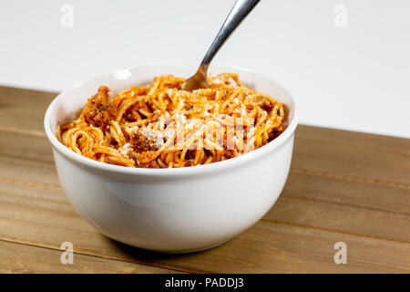 Spaghetti Bolognese in einem tiefen weiße Schüssel auf dem hölzernen Küchentisch warten gegessen zu werden. Stockfoto