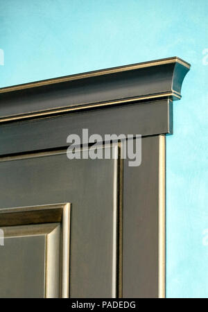 Element der Holztür im Rahmen des Ebenholz schwarz-goldenen Holz im klassischen Stil auf Blau verputzte Wand Hintergrund geschnitzten Nahaufnahme Stockfoto