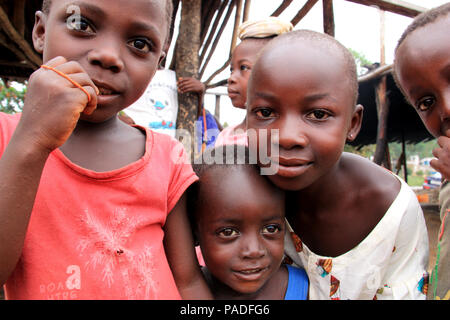 Blick auf neugierige afrikanische Kinder, die sich in einer Palmöl-Produktionsstätte in der Nähe von Cape Coast in Ghana versammeln und die Kamera betrachten Stockfoto