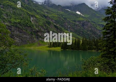 See, in einem Tal in den Kitzbüheler Alpen in Österreich. Bäume spiegeln sich im Wasser Stockfoto