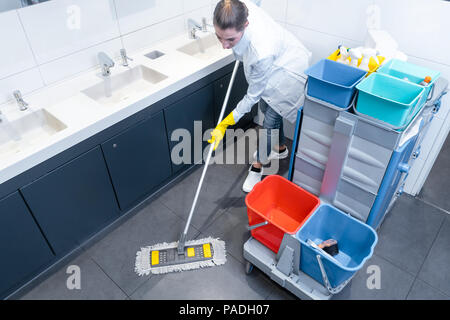 Putzfrau wischen den Boden in Toilette Stockfoto