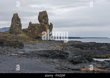 Londrangar Basaltfelsen Island von den weniger fotografiert Seite, die über einen Pfad, die es Ihnen ermöglicht, über einen felsigen Strand an den Klippen zu gehen gesehen Stockfoto