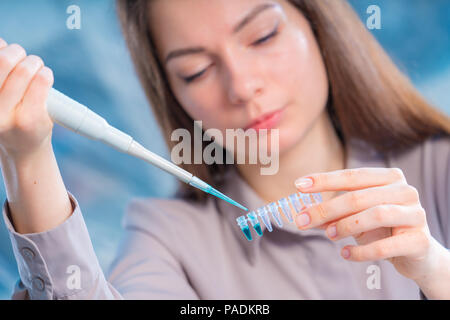 Technikerin mit Pipette in Kop für DNA die gerichtliche Prüfung Stockfoto