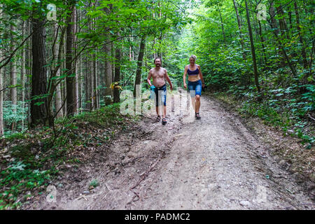 Paar, Mann und Frau, die zu Fuß auf einem Waldweg im Sommer Wärme, Tschechische Republik Stockfoto