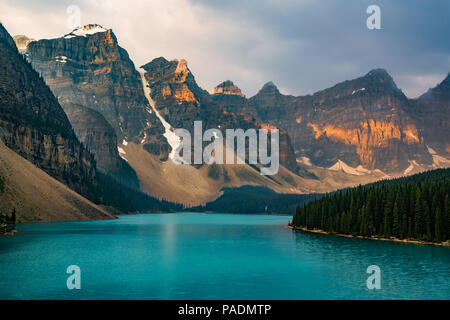 Sonnenaufgang mit türkisfarbenen Wasser des Lake Moraine mit Sünde lit Rocky Mountains im Banff Nationalpark Kanadas in Tal der zehn Gipfel. Stockfoto