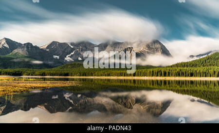 Reflexion mit See und Bergen niedrig hängenden couds im Lower Kananaskis See von Peter Lougheed Provincial Park Kananaskis Country Alberta Kanada Stockfoto