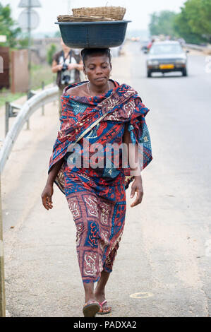 - PORTO NOVO, BENIN - Mar 9, 2012: Unbekannter beninischen Frau mit viel Material über den Kopf. Kinder von Benin Leiden der Armut aufgrund der schwierigen Stockfoto