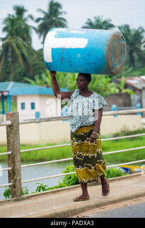 - PORTO NOVO, BENIN - Mar 9, 2012: Unbekannter beninischen Frau mit viel Material über den Kopf. Kinder von Benin Leiden der Armut aufgrund der schwierigen Stockfoto