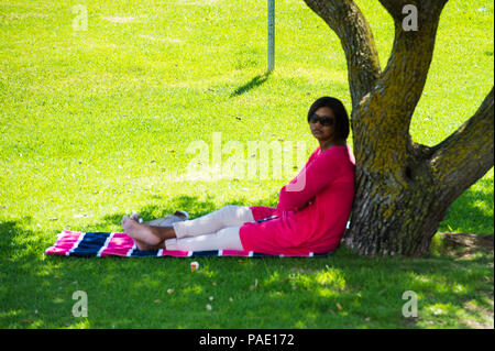 Südafrika - Februar, 22-2013: Nicht identifizierte Frau nimmt einen Rest im Park in Südafrika, Feb 22, 2013. Die Menschen in Südafrika haben verschiedene Ursprünge, Stockfoto