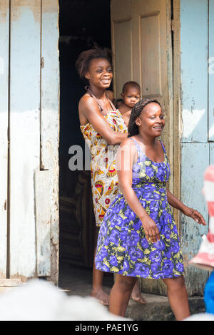 LIBREVILLE, Gabun - Mar 6, 2013: Unbekannter gabunischen Frau hält Ihr Baby und bleibt auf der Veranda in Gabun, Mar 6, 2013. Menschen in Gabun Leiden von Po Stockfoto