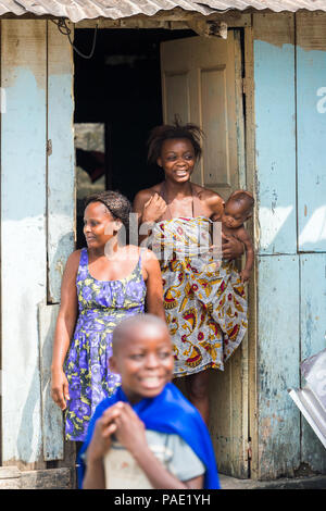 LIBREVILLE, Gabun - Mar 6, 2013: Unbekannter gabunischen Frau hält Ihr Baby und bleibt auf der Veranda in Gabun, Mar 6, 2013. Menschen in Gabun Leiden von Po Stockfoto