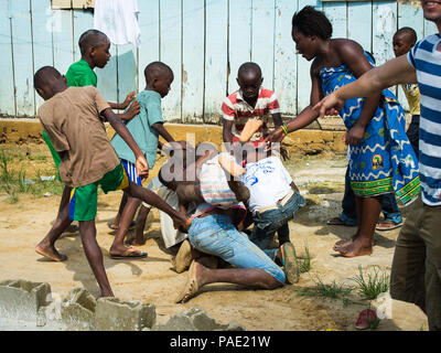 LIBREVILLE, Gabun - Mar 6, 2013: Unbekannter gabunischen Frau versucht den Kampf gegen die Kinder in Gabun, Mar 6, 2013 zu beruhigen. Menschen in Gabun Leiden von Stockfoto
